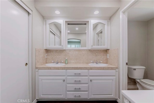 full bath featuring toilet, tasteful backsplash, and double vanity