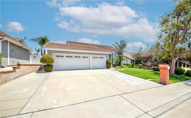 view of front of property featuring driveway, a front yard, and an attached garage