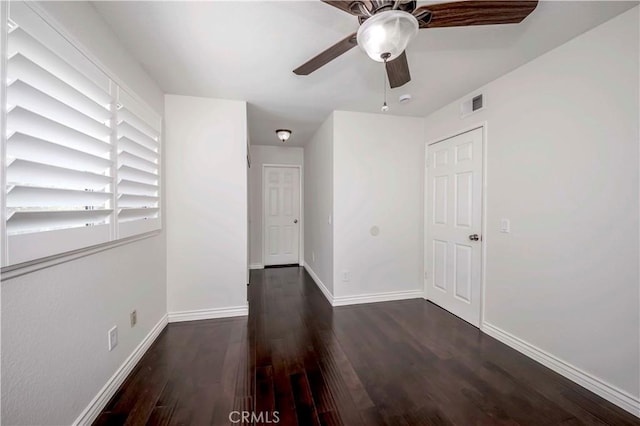 empty room with wood finished floors, baseboards, and ceiling fan