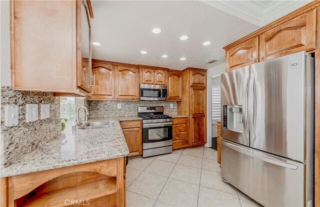 kitchen featuring appliances with stainless steel finishes, a sink, recessed lighting, ornamental molding, and decorative backsplash
