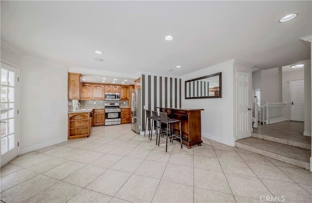 kitchen with appliances with stainless steel finishes, crown molding, recessed lighting, light countertops, and baseboards