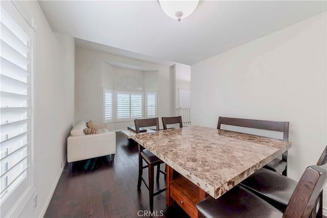 dining area with dark wood-style flooring and baseboards