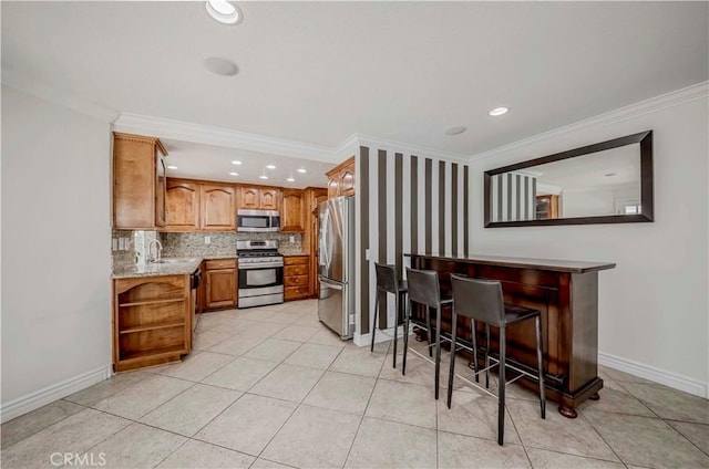 kitchen featuring appliances with stainless steel finishes, crown molding, baseboards, brown cabinetry, and recessed lighting
