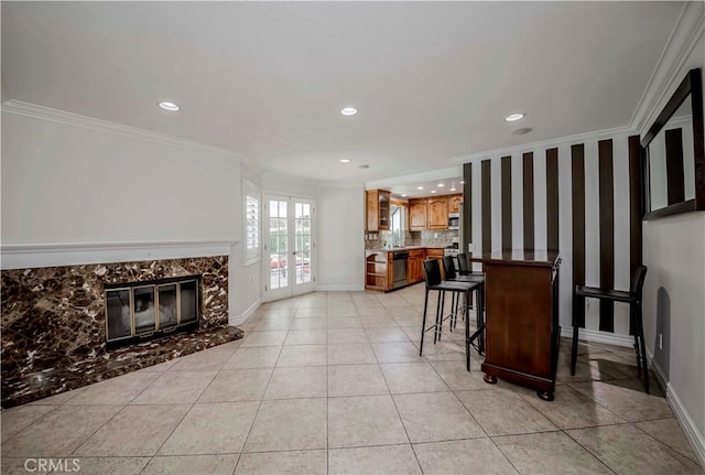 living room featuring recessed lighting, crown molding, light tile patterned flooring, baseboards, and a high end fireplace