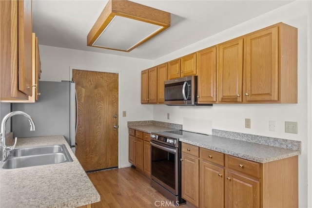 6383 Harvey Rd, Paradise, CA 95969 - kitchen featuring stainless steel appliances, a sink, wood finished floors, light countertops, and brown cabinetry