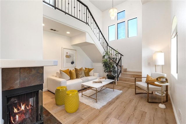 4286 W 182nd St Unit A, Torrance, CA 90504 - living area with wood finished floors, stairs, a towering ceiling, baseboards, and a tile fireplace