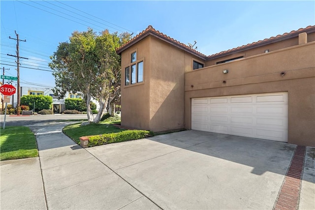 4286 W 182nd St Unit A, Torrance, CA 90504 - view of side of home with stucco siding, driveway, a tile roof, and a garage
