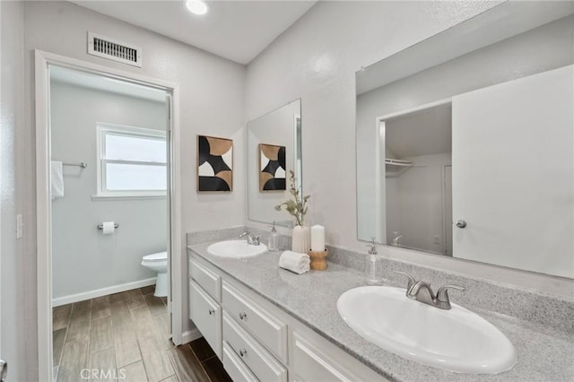1530 N Grove St, Redlands, CA 92374 - bathroom featuring toilet, double vanity, wood finished floors, and baseboards
