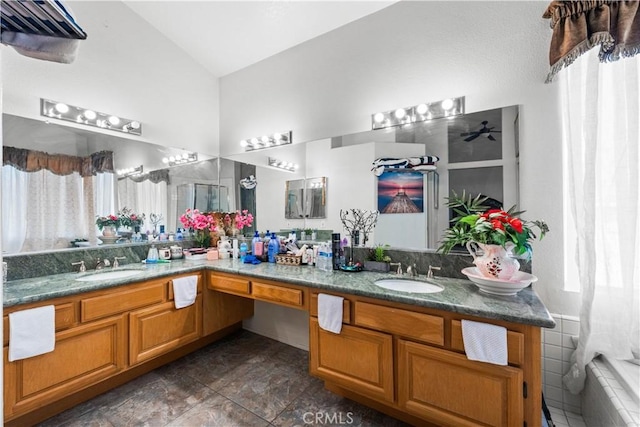3410 Genoa Pl, Palmdale, CA 93551 - bathroom with vaulted ceiling, double vanity, and a relaxing tiled tub
