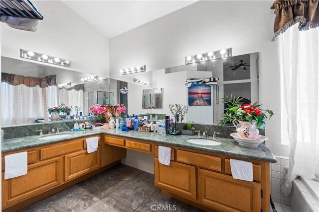 3410 Genoa Pl, Palmdale, CA 93551 - bathroom featuring lofted ceiling, double vanity, and a relaxing tiled tub