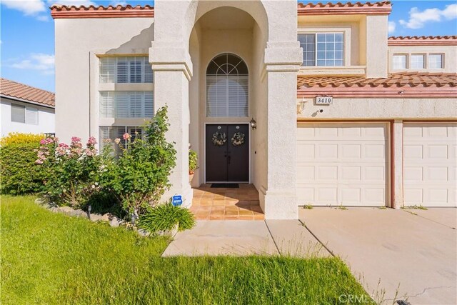 3410 Genoa Pl, Palmdale, CA 93551 - entrance to property featuring stucco siding, driveway, and a tile roof