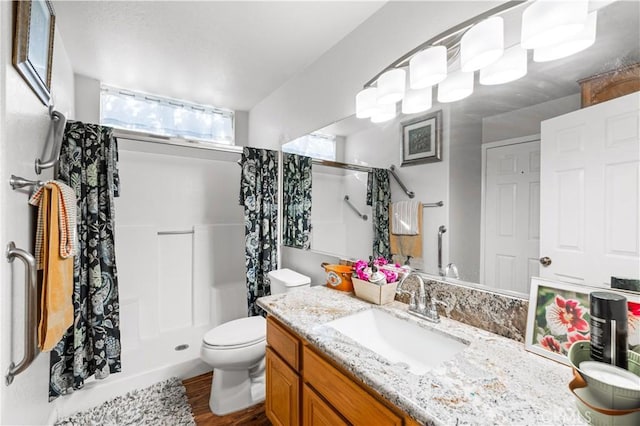 3410 Genoa Pl, Palmdale, CA 93551 - full bathroom with a stall shower, toilet, vanity, and wood finished floors