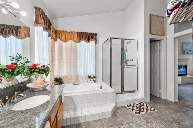 3410 Genoa Pl, Palmdale, CA 93551 - bathroom featuring a garden tub, a stall shower, double vanity, a glass covered fireplace, and lofted ceiling