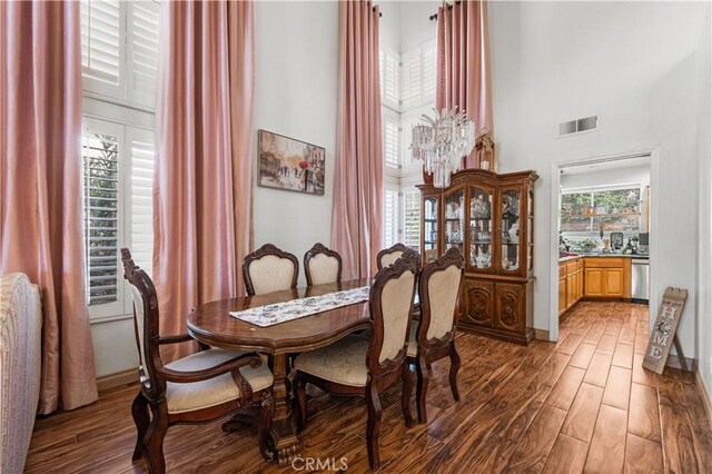 3410 Genoa Pl, Palmdale, CA 93551 - dining area with a high ceiling, wood finished floors, healthy amount of natural light, and a chandelier