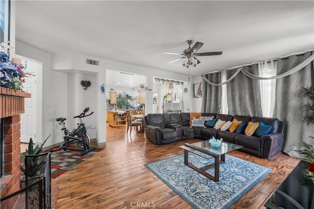 3410 Genoa Pl, Palmdale, CA 93551 - living area with a ceiling fan, wood finished floors, and a brick fireplace