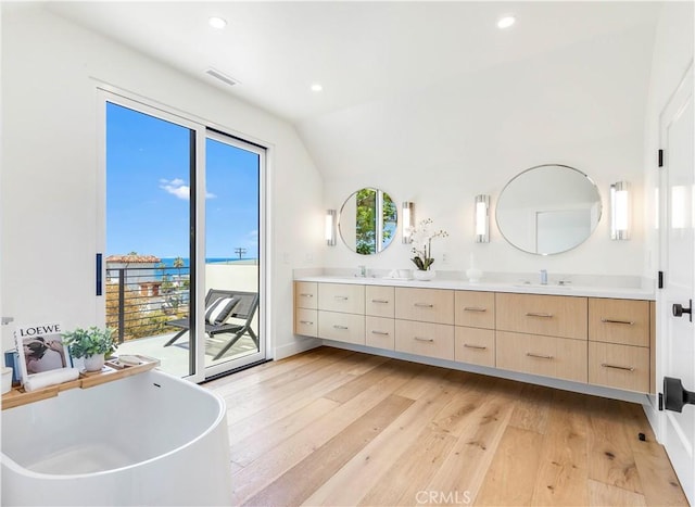1759 Glenneyre St, Laguna Beach, CA 92651 - bathroom with wood-type flooring, double vanity, a freestanding bath, recessed lighting, and vaulted ceiling