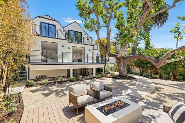 1759 Glenneyre St, Laguna Beach, CA 92651 - back of house featuring a balcony, an outdoor fire pit, stucco siding, fence, and a patio