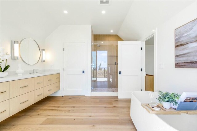 1759 Glenneyre St, Laguna Beach, CA 92651 - bathroom featuring vaulted ceiling, a shower stall, vanity, wood finished floors, and a soaking tub
