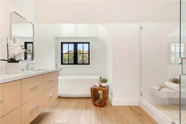 1759 Glenneyre St, Laguna Beach, CA 92651 - full bath with wood finished floors, a shower stall, a freestanding tub, vanity, and baseboards