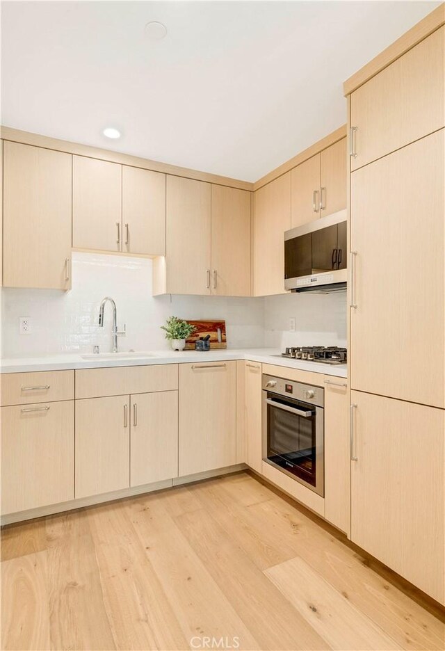 1759 Glenneyre St, Laguna Beach, CA 92651 - kitchen with stainless steel appliances, a sink, light wood-type flooring, light countertops, and light brown cabinetry