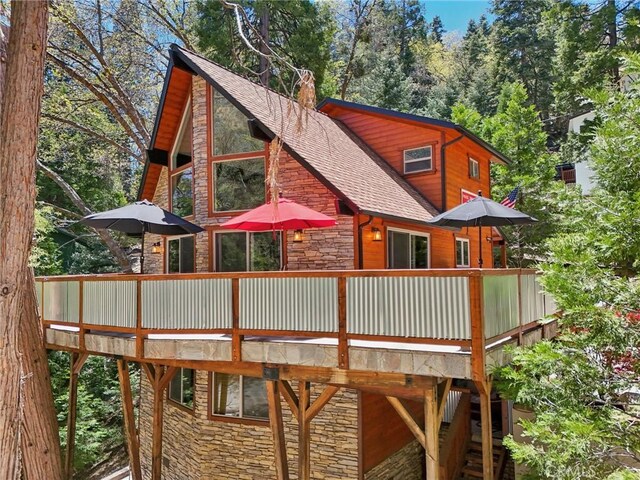 385 Iris Dr, Twin Peaks, CA 92391 - rear view of house with stone siding, a wooden deck, and a shingled roof