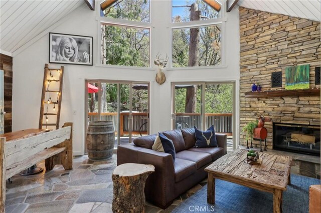 385 Iris Dr, Twin Peaks, CA 92391 - living area with high vaulted ceiling, stone tile floors, wood ceiling, and a fireplace