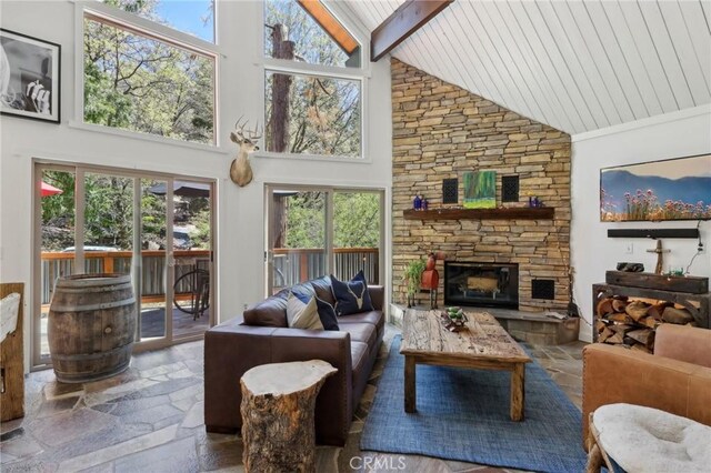 385 Iris Dr, Twin Peaks, CA 92391 - living room featuring high vaulted ceiling, stone tile flooring, beamed ceiling, a stone fireplace, and wooden ceiling