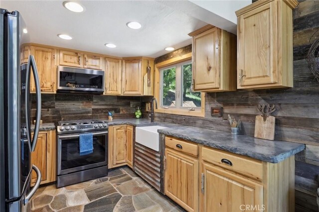 385 Iris Dr, Twin Peaks, CA 92391 - kitchen with stainless steel appliances, light brown cabinets, backsplash, dark countertops, and a sink
