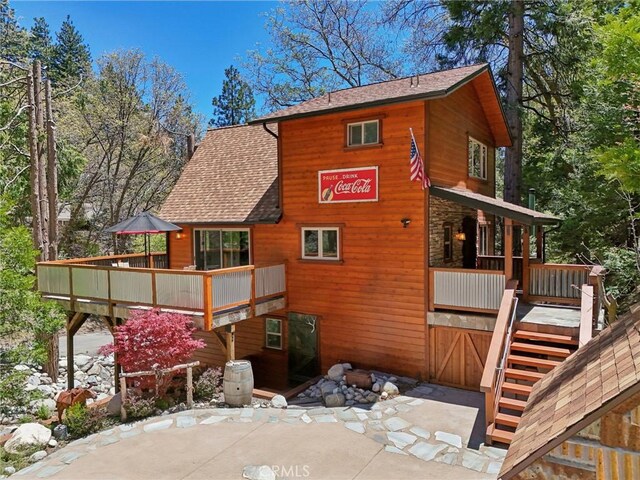 385 Iris Dr, Twin Peaks, CA 92391 - back of house with a shingled roof and stairway