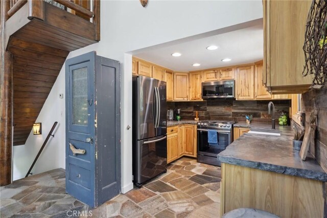 385 Iris Dr, Twin Peaks, CA 92391 - kitchen featuring appliances with stainless steel finishes, a sink, stone finish floors, dark countertops, and recessed lighting