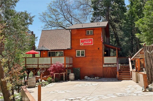 385 Iris Dr, Twin Peaks, CA 92391 - back of house featuring stairs, a shingled roof, and a wooden deck