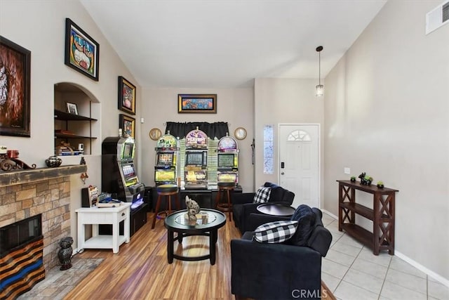 12427 Stardell Ln, Yucaipa, CA 92399 - living room featuring a glass covered fireplace, vaulted ceiling, baseboards, light tile patterned flooring, and built in features
