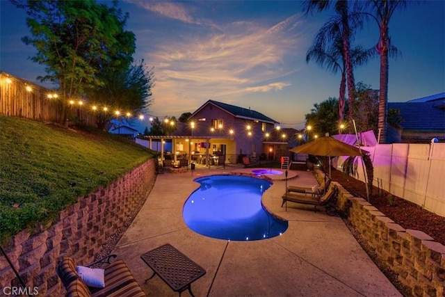 12427 Stardell Ln, Yucaipa, CA 92399 - pool at dusk featuring a patio area, a fenced backyard, and a pool with connected hot tub