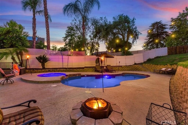 12427 Stardell Ln, Yucaipa, CA 92399 - pool at dusk with an outdoor fire pit, a fenced backyard, a patio area, and a pool with connected hot tub