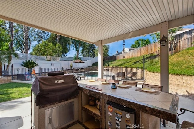 12427 Stardell Ln, Yucaipa, CA 92399 - view of patio with a fenced backyard, exterior kitchen, a bar, and a grill