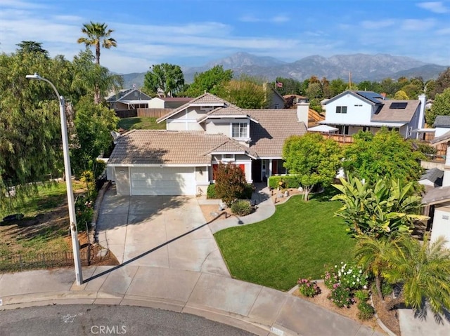 12427 Stardell Ln, Yucaipa, CA 92399 - view of front facade with a tiled roof, concrete driveway, a garage, and a mountain view