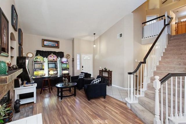 12427 Stardell Ln, Yucaipa, CA 92399 - living area featuring stairs, wood finished floors, a tile fireplace, and high vaulted ceiling