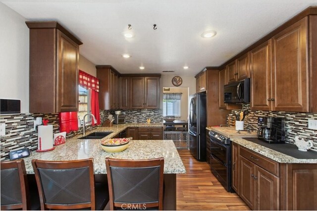 12427 Stardell Ln, Yucaipa, CA 92399 - kitchen with freestanding refrigerator, a sink, range with two ovens, wood finished floors, and a peninsula