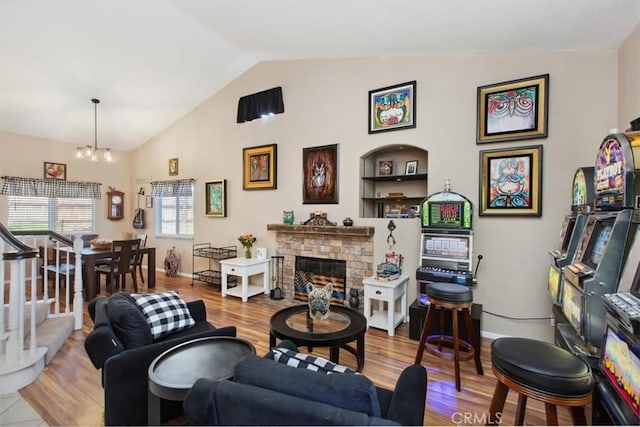 12427 Stardell Ln, Yucaipa, CA 92399 - living room with a chandelier, wood finished floors, a stone fireplace, high vaulted ceiling, and baseboards