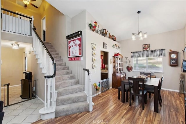 12427 Stardell Ln, Yucaipa, CA 92399 - dining room with stairs, a chandelier, wood finished floors, baseboards, and high vaulted ceiling