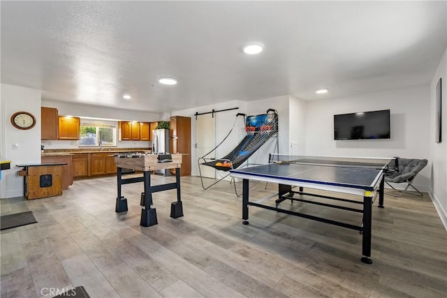2245 Rancho Lomas Way, San Miguel, CA 93451 - rec room featuring light wood-style flooring, a sink, recessed lighting, baseboards, and a barn door