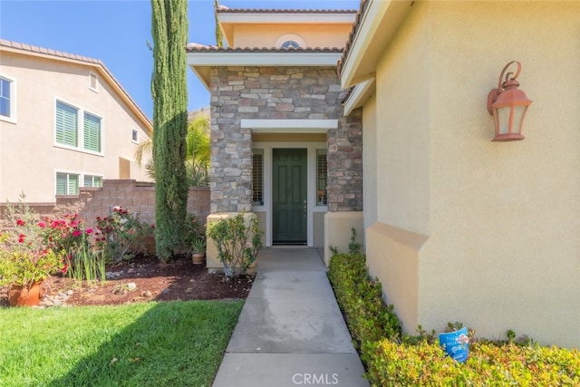 34130 Camelina St, Lake Elsinore, CA 92532 - view of exterior entry featuring stone siding, stucco siding, and fence