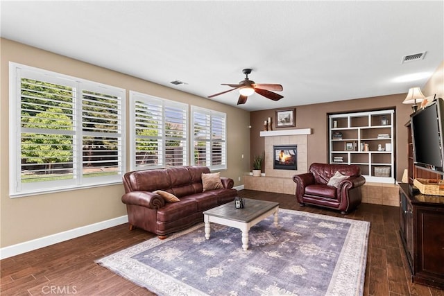 1689 Hometown Ln, Manteca, CA 95337 - living area with a ceiling fan, dark wood-style floors, a tile fireplace, and baseboards