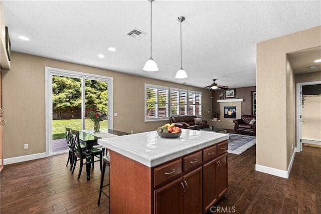 1689 Hometown Ln, Manteca, CA 95337 - kitchen with tile countertops, dark wood-style floors, baseboards, a fireplace, and recessed lighting