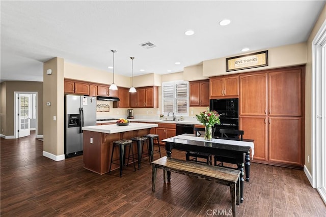 1689 Hometown Ln, Manteca, CA 95337 - kitchen featuring black appliances, a center island, under cabinet range hood, light countertops, and recessed lighting