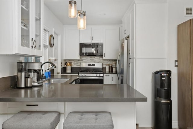 15576 Paseo Ajanta, San Diego, CA 92129 - kitchen featuring appliances with stainless steel finishes, a sink, dark countertops, and white cabinets
