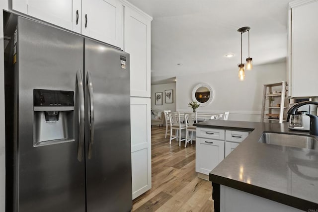 15576 Paseo Ajanta, San Diego, CA 92129 - kitchen with stainless steel fridge, a sink, dark countertops, white cabinets, and light wood-type flooring