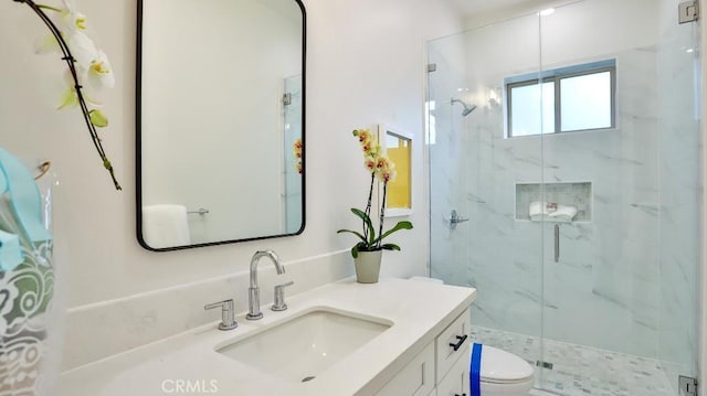bathroom featuring a marble finish shower, toilet, and vanity
