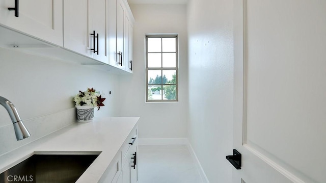 bar area featuring a sink and baseboards