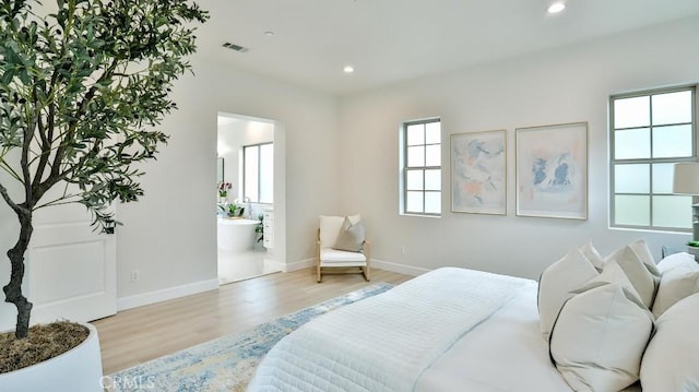 bedroom with wood finished floors, recessed lighting, baseboards, and ensuite bath